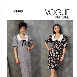 May include: Vogue Patterns V1905. Two dresses are shown, one with a gray plaid pattern and the other with a black floral print. Both dresses have a white collar and short puff sleeves. The pattern is designed and printed in the USA.