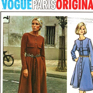 Könnte beinhalten: Ein Vintage-Cover des Modemagazins Vogue Paris Original. Das Cover zeigt eine Frau in einem braunen Knopfkleid und Stiefeln sowie eine Modeillustration eines blauen Kleides. Der Text "VOGUE PARIS ORIGINAL" und "LANVIN" sind sichtbar.