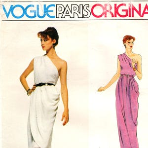 以下が含まれることがあります： Vogue Paris Original のソーイングパターン。片方の肩が出たドレスが2種類あります。1つは黒いベルトが付いた白、もう1つは長いピンク色のガウンです。パターンにはGivenchyのロゴと番号2307が含まれています。