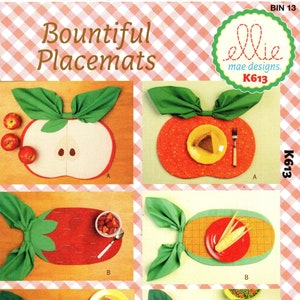 May include: A sewing pattern for Bountiful Placemats featuring four different designs: an apple, a strawberry, a watermelon, and a pea pod. The pattern is by ellie mae designs and has the number K613.