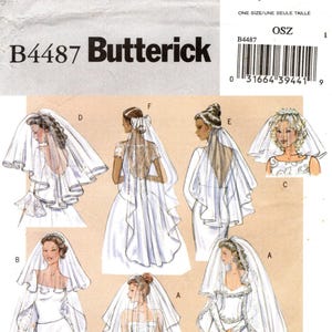 Puede incluir: Patrón de costura Butterick B4487 para velos de novia en varios largos y estilos. El sobre presenta ilustraciones de seis diseños de velo diferentes etiquetados de la A a la F, usados con vestidos de novia, incluyendo detalles como encaje y lazos.