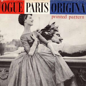 Puede incluir: Una fotografía en blanco y negro de una mujer con un vestido de falda completa y tacones altos. El vestido está diseñado por Jacques Heim. La foto es de un patrón impreso original de Vogue Paris.