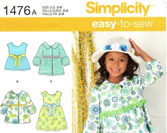 May include: A sewing pattern for a girl's dress and pants. The pattern includes a dress with a bow, a dress with a collar, a dress with a ruffle, and pants with a ruffle. The pattern is for sizes 3-8. The pattern is from Simplicity and is easy to sew.