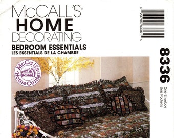 Könnte beinhalten: Ein McCall's Home Decorating-Muster für ein Tagesbett mit einem Volant und Kissen. Das Muster heißt "Bedroom Essentials" und die Musternummer ist 8336. Das Tagesbett ist mit einem Stoff mit einem Muster aus Häusern bezogen.
