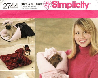May include: A sewing pattern for making dog beds and carriers. The pattern includes four different designs: a red and black bed, a white and pink bed, a pink carrier, and a pink and blue bed. The pattern is from Simplicity and is size A for all sizes.