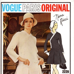 Könnte beinhalten: Ein Vintage-Schnittmuster von Vogue Paris Original mit einem weißen Kleid mit Wickeldesign und einem schwarzen Kleid mit kontrastierendem weißem Kragen. Die Schnittmuster-Nummer ist 2229 und die Designerin ist Nina Ricci.