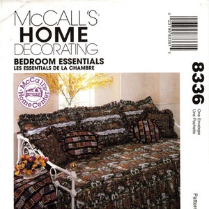 May include: A McCall's Home Decorating pattern for a daybed with a ruffled skirt and pillows. The pattern is called "Bedroom Essentials" and the pattern number is 8336. The daybed is covered in a fabric with a pattern of houses.