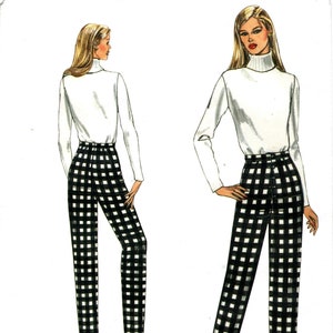 Può includere: Un cartamodello per pantaloni a quadri bianco e nero con vita alta e una maglia bianca a collo alto. Vogue Patterns 1003.
