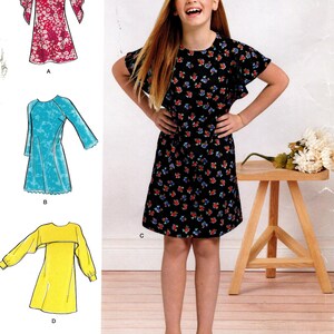 May include: Simplicity sewing pattern D0909 AA for girls' dresses, sizes 8-16. The image shows a girl wearing a black dress with a floral pattern. Other dress designs include a red floral dress, a blue dress, and a yellow top with sleeves.