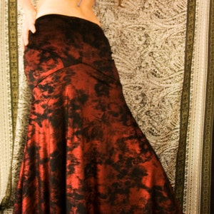 May include: A red and black patterned maxi skirt with a mermaid style hem.