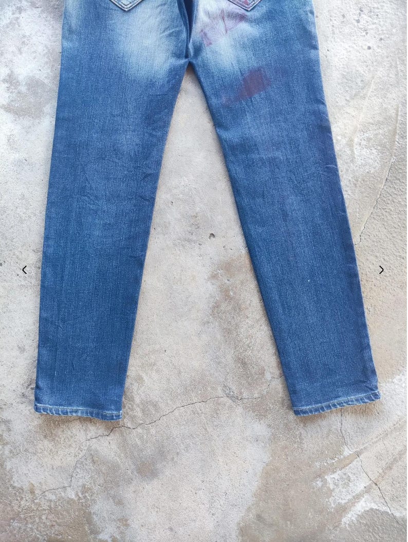 Puede incluir: Vaqueros azules con un lavado descolorido y una mancha en la parte trasera. Los vaqueros tienen un dise&ntilde;o cl&aacute;sico de cinco bolsillos y un corte de pierna recta. Los bolsillos traseros tienen costuras decorativas.