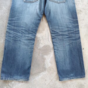 Peut inclure: Jean en denim bleu clair avec des coutures d&eacute;taill&eacute;es sur les poches arri&egrave;re. Le jean pr&eacute;sente un d&eacute;lavage et des d&eacute;tails subtils. Le style g&eacute;n&eacute;ral est d&eacute;contract&eacute; et classique, adapt&eacute; au quotidien.