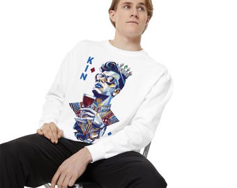 May include: White sweatshirt with a graphic print of a person wearing a crown and sunglasses, holding a glass of wine. The text "KING" is printed vertically on the left side of the graphic.