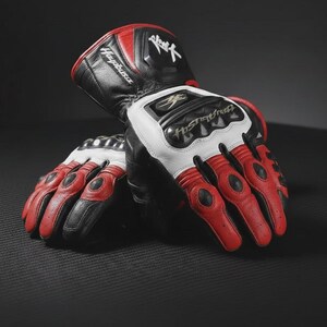 Peut inclure: Paire de gants de moto noirs, rouges et blancs. Les gants arborent un logo Hayabusa sur le poignet. Les doigts sont rouges avec des détails noirs. Fabriqués en cuir, ils possèdent des protections aux articulations.