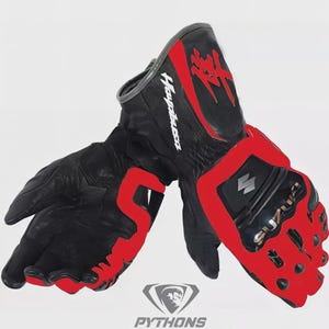 Op de afbeelding: Zwarte en rode motorhandschoenen met het woord "Hayabusa" in het wit. De handschoenen hebben rode accenten en het Suzuki-logo. De handschoenen zijn gemaakt van leer en hebben onderaan een "Pythons"-logo.