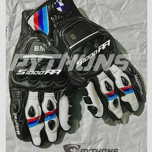 May include: Black leather motorcycle gloves with white and red-blue accents. The gloves feature the BMW logo and the text "S1000RR". The gloves are labeled "Motorrad" and "Pythons Racing Gear".