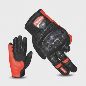 Peut inclure: Une paire de gants de moto noirs et rouges arborant le logo Ducati Corse sur la sangle du poignet. Les gants comprennent des protections de phalanges en fibre de carbone, un rembourrage de paume renforcé et des panneaux en cuir texturé.
