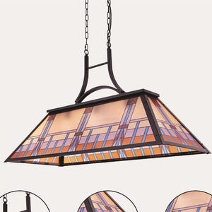 May include: Rectangular pendant light fixture with a stained glass shade. The shade features a geometric pattern in shades of orange, blue, and purple, framed by a dark metal border. The fixture hangs from chains and has a dark metal frame.