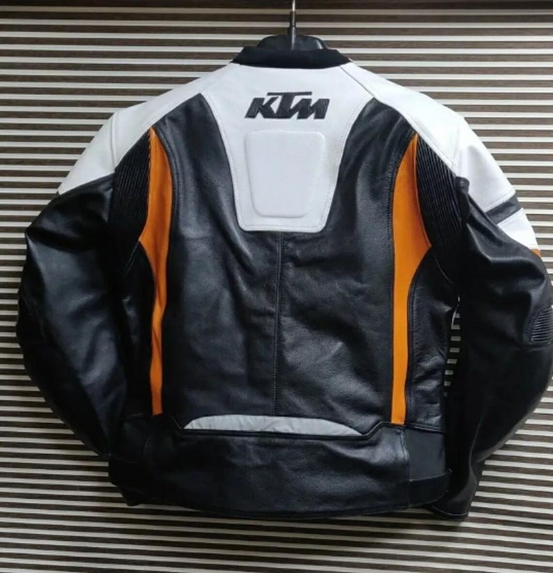 May include: Black, white, and orange leather motorcycle jacket with the KTM logo on the back.