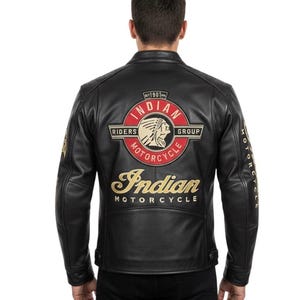 Peut inclure: Veste de moto en cuir noir avec des écussons brodés dorés et rouges. Le dos présente un grand écusson avec les mots "Indian Motorcycle Riders Group" et un profil amérindien. La veste porte également l'inscription "Indian Motorcycle" en lettres dorées.