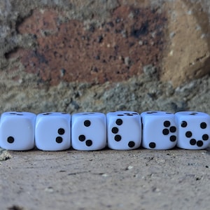 May include: Six white dice with black dots are arranged in a row. The dice show different numbers from one to six. The dice are on a brick surface with a brick wall in the background.