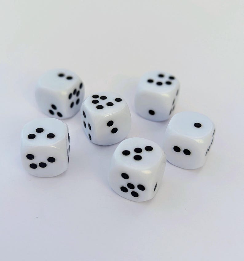 May include: Six white dice with black dots are arranged on a white surface. Each die has a different number of dots, ranging from one to six. The dice are evenly spaced and appear to be new.
