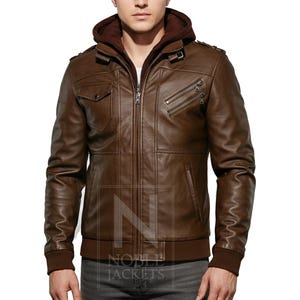 May include: Brown leather jacket with a zip-up front, a hood, and multiple pockets. The jacket has a ribbed hem and cuffs. The jacket is a medium brown color and appears to be made of leather.