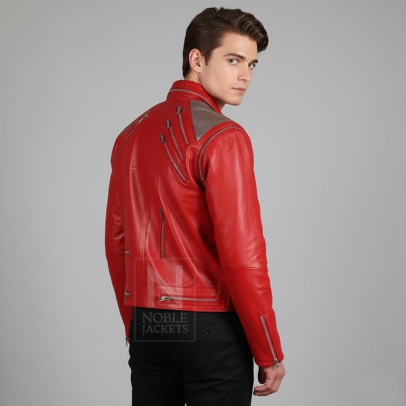 Puede incluir: Chaqueta de cuero roja brillante con cremalleras plateadas y un panel de malla en los hombros. La chaqueta tiene un estilo motero cl&aacute;sico con cuello alzado y m&uacute;ltiples bolsillos con cremallera. El texto "NOBLE JACKETS" es visible.