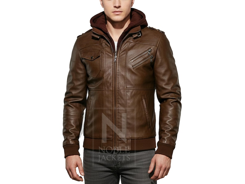 May include: Brown leather jacket with a zip-up front, a hood, and multiple pockets. The jacket has a ribbed hem and cuffs. The jacket is a medium brown color and appears to be made of leather.