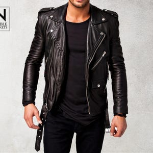 Puede incluir: Una chaqueta de cuero negra para moto con cierre de cremallera y varios bolsillos. La chaqueta tiene un estilo motero clásico.