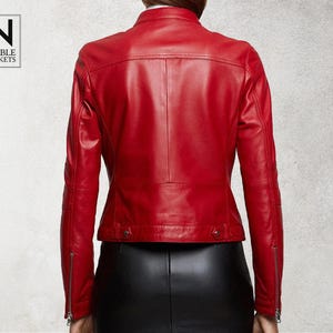 May include: A red leather jacket with a zip fastening and a stand-up collar. The jacket has a slim fit and is made of soft, supple leather.