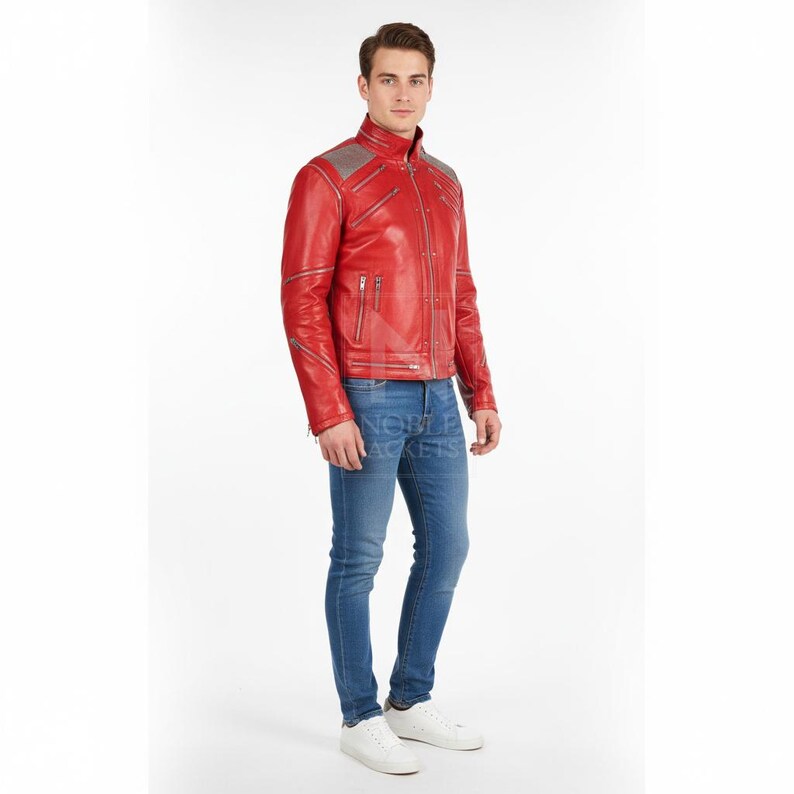 Puede incluir: Chaqueta de cuero roja con cremalleras y detalles plateados. La chaqueta tiene un cuello alzado y un dise&ntilde;o acolchado en los hombros. La persona lleva vaqueros azules y zapatillas blancas.