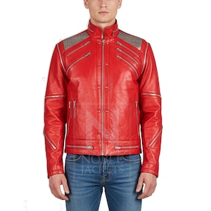 Puede incluir: Chaqueta de cuero roja brillante con cremalleras y detalles plateados. La chaqueta tiene cuello alto, m&uacute;ltiples bolsillos con cremallera y detalles plateados en los hombros. Se usa con vaqueros azules. La marca "NOBLE JACKETS" es visible.