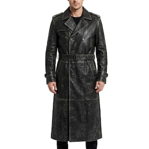 May include: A long, double-breasted black leather trench coat featuring a wide collar, shoulder epaulets, and a matching waist belt with a buckle. The coat has long sleeves with adjustable cuff straps and a distressed, weathered finish throughout.