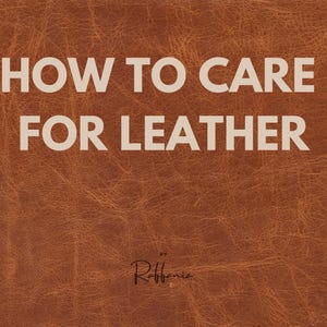 Op de afbeelding: Close-up van een bruin leren oppervlak met de tekst "HOW TO CARE FOR LEATHER" in het wit. De tekst "by Raffania" staat eronder in een scriptlettertype.