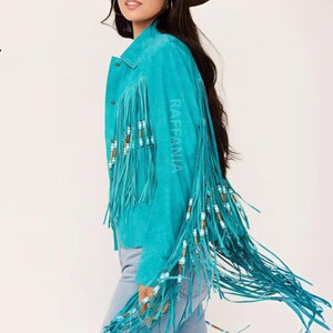Puede incluir: Una chaqueta de ante color turquesa brillante con largos flecos en las mangas y la espalda. Los flecos est&aacute;n decorados con peque&ntilde;as cuentas cil&iacute;ndricas en blanco, marr&oacute;n y turquesa. La chaqueta tiene un cuello cl&aacute;sico y botones de presi&oacute;n.
