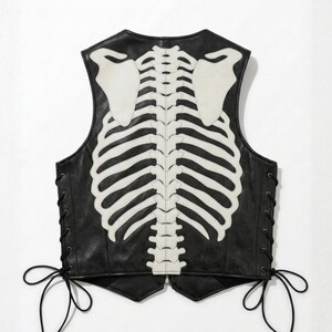 Back profile of men's leather vest showing detailed white skeleton ribcage embroidery on black leather.