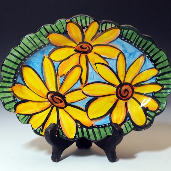 Hand-painted majolica-style pottery with bold sunflower-on-blue motif — a tiny functional art piece that looks like it came from a European market stall.