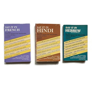 May include: Three colorful paperback books with the title "Say it in" followed by the language in which the book teaches you to speak. The books are French, Hindi, and Hebrew. Each book has a description of the features of the book.