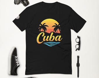 May include: Black t-shirt featuring a graphic of a sunset over palm trees and the word "Cuba" in a yellow, orange, and blue colour scheme.