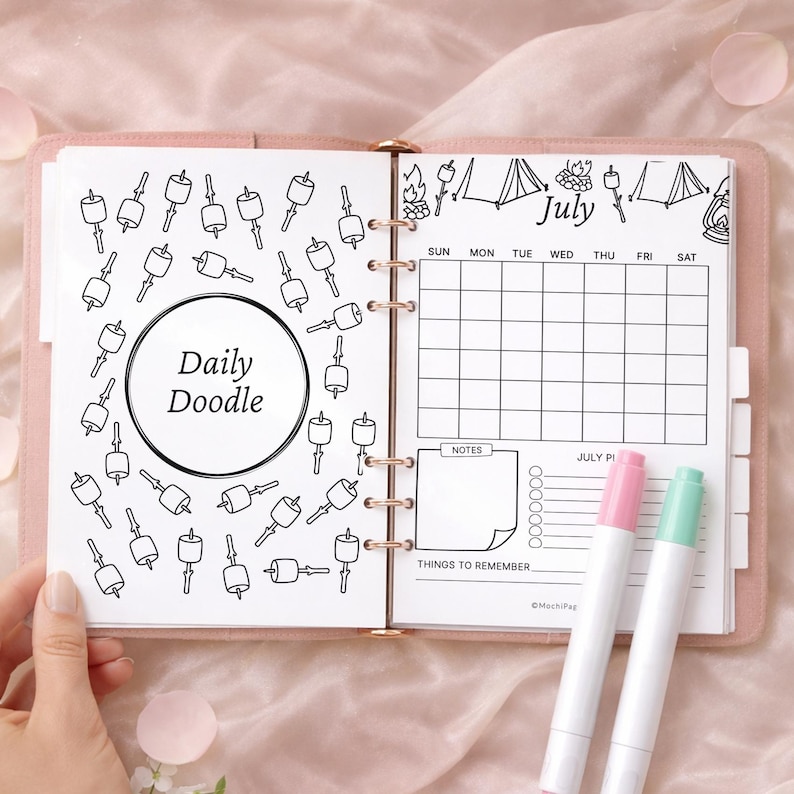 May include: A pink planner open to a July calendar page with a doodle theme. The left page has a "Daily Doodle" circle surrounded by marshmallow illustrations. The right page includes a calendar, notes section, and two highlighters.