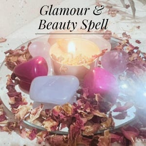 Puede incluir: Una vela encendida se encuentra entre cristales rosas y morados, pétalos de rosa y un espejo. El texto "Glamour & Beauty Spell" es visible. La imagen es un primer plano de un arreglo espiritual o metafísico.