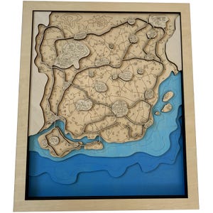 May include: A wooden 3D map of a coastal area with a blue ocean and brown land. The map is framed in a light wood frame.