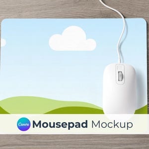 May include: A white computer mouse with a scroll wheel rests on a rectangular mousepad. The mousepad features a sky-blue background with white clouds and green hills. The text "Mousepad Mockup" is displayed.