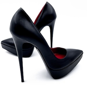 Peut inclure: Une paire d'escarpins noirs à talons hauts avec des bouts pointus et des talons aiguilles. L'intérieur des chaussures est rouge. Les talons compensés mesurent environ 2,5 cm de haut, et les talons aiguilles mesurent environ 12,7 cm de haut.