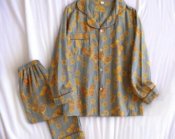 May include: A gray and yellow pajama set with a butterfly print. The top has long sleeves and a button-up front. The pants have an elastic waistband.