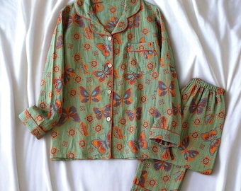 May include: Green pajamas with a butterfly print. The top has a button-up front and long sleeves. The pants have an elastic waistband.