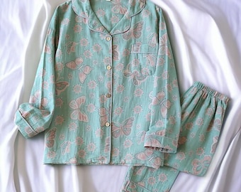 May include: A green and pink pajama set with a butterfly print. The top has long sleeves and a button-up front. The pants are long and have an elastic waistband.