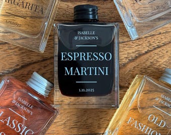 May include: An assortment of square glass bottles with black labels, each containing a different cocktail. The central bottle reads "Espresso Martini" with the date 1.11.2025. Other bottles are labeled "Spicy Margarita", "Dry Martini", "Classic Cosmo", and "Old Fashioned".