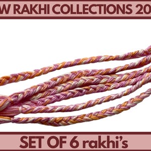 May include: Six braided rakhi bracelets in pink, orange, and white. The image shows the text "NEW RAKHI COLLECTIONS 2026" and "SET OF 6 rakhi's" within a maroon frame, showcasing the collection.